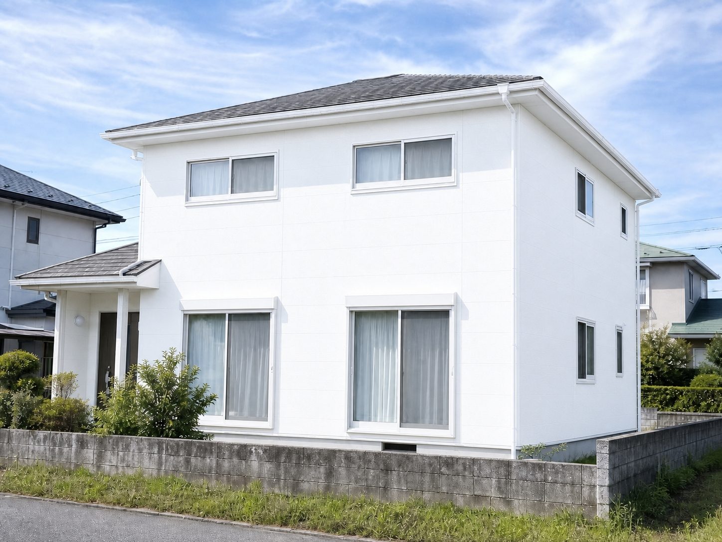 塗り替えを終えて白く仕上がった住宅の外壁